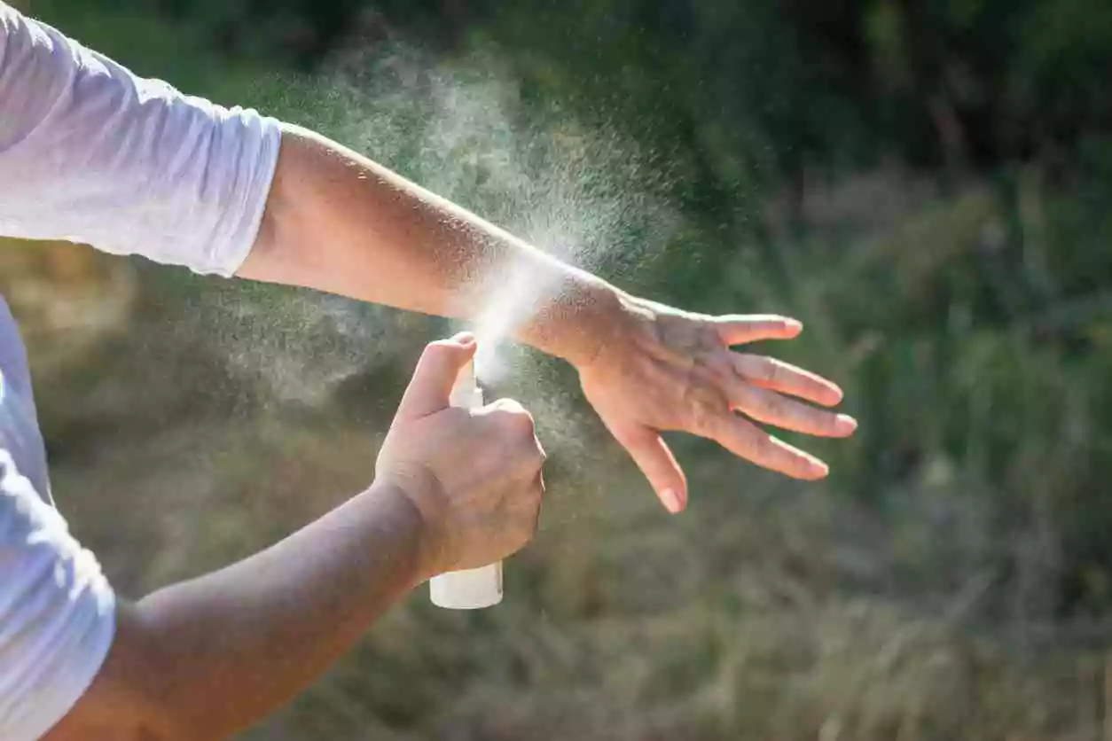 image of man using insect repellent